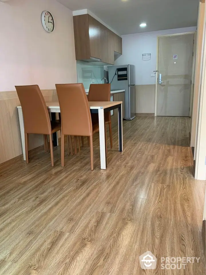 Modern dining area with wooden flooring and sleek furniture in a stylish apartment.