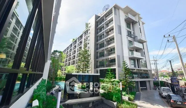 Modern condominium complex with lush greenery and spacious balconies.