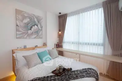 Modern bedroom with stylish decor and large window for natural light.