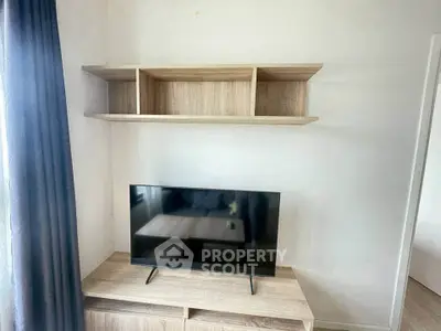 Modern living room with sleek TV stand and wall-mounted shelves, perfect for stylish urban living.
