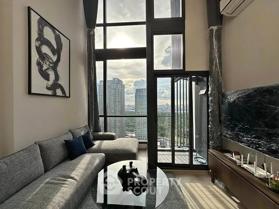 Luxurious high-rise living room with floor-to-ceiling windows and stunning city view.