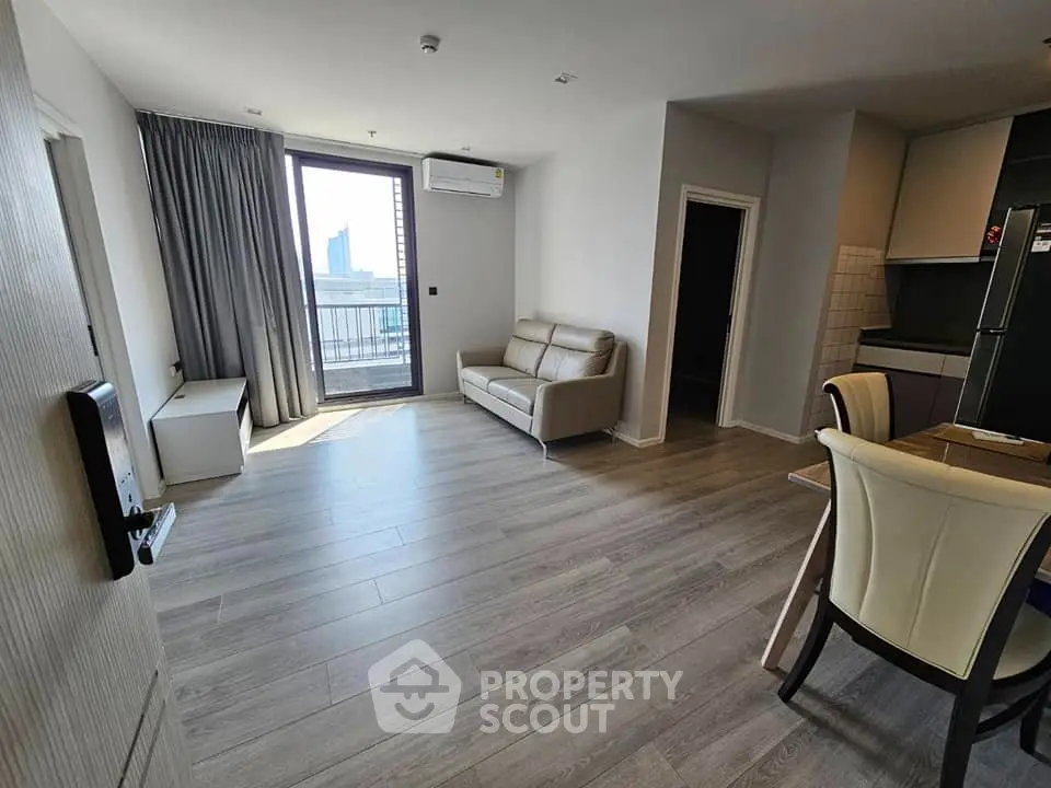 Modern living room with balcony view and sleek kitchen area
