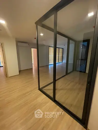 Spacious modern interior with glass partition and wooden flooring