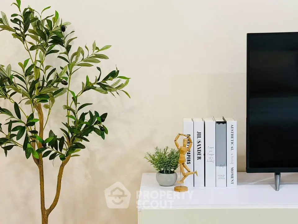 Modern living room with stylish decor and flat-screen TV on a sleek white console.