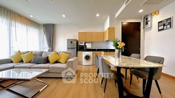 Modern open-plan living room and kitchen with stylish furniture and appliances.