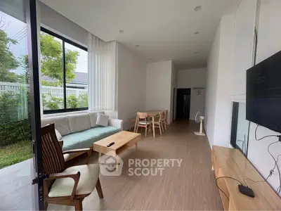 Spacious modern living room with large windows and elegant furniture, perfect for relaxation and entertainment.