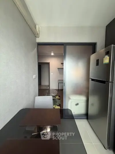 Modern kitchen with sleek design and stainless steel fridge in a cozy apartment.