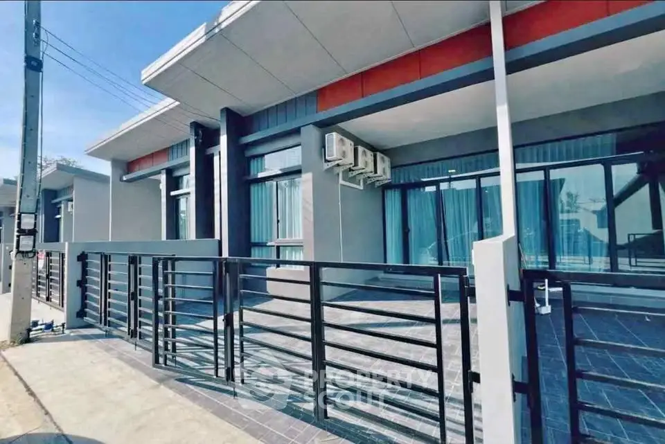 Modern single-story home with sleek design and large windows, featuring a secure gated entrance.
