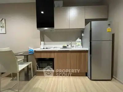 Modern kitchen with sleek cabinetry and stainless steel appliances in a stylish apartment.