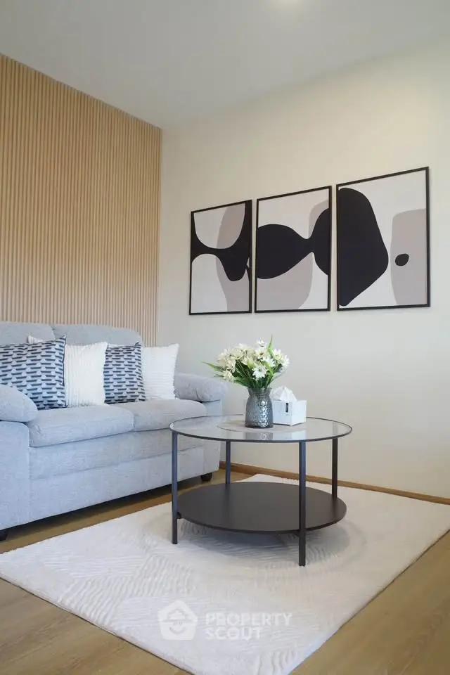 Modern living room with stylish decor and abstract art, featuring a cozy sofa and elegant coffee table.
