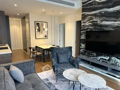 Modern living room with stylish decor and open layout, featuring a marble accent wall and cozy seating area.