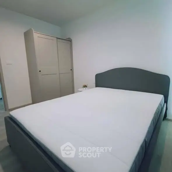 Spacious bedroom with modern bed and wardrobe in a minimalist design.