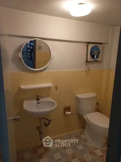 Cozy bathroom with vintage yellow tiles and modern fixtures, perfect for a compact living space.