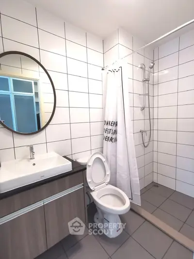 Modern bathroom with sleek fixtures and walk-in shower in contemporary apartment.