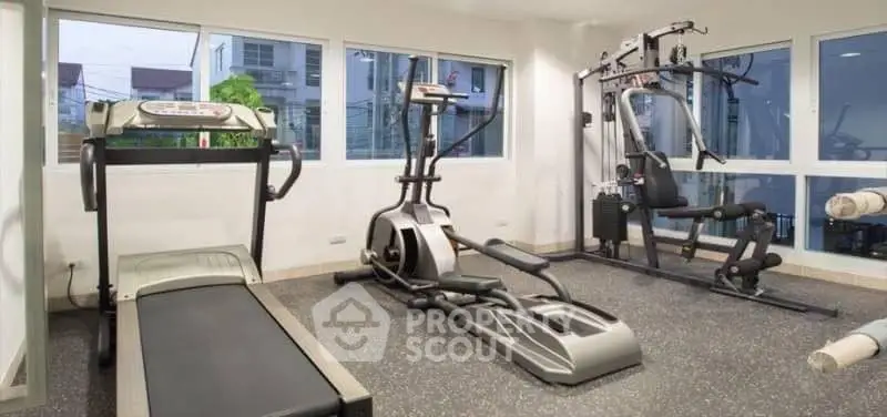 Modern gym with state-of-the-art exercise equipment and large windows for natural light.