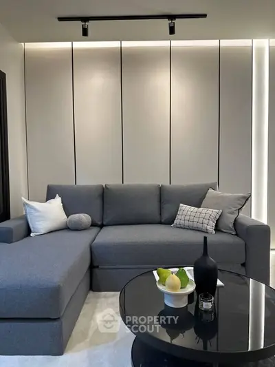 Modern living room with sleek gray sectional sofa and stylish coffee table