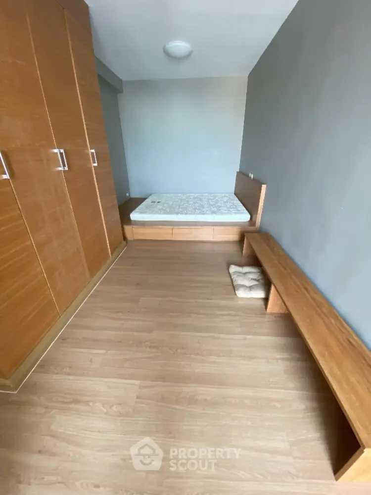 Spacious bedroom with wooden flooring and built-in wardrobe