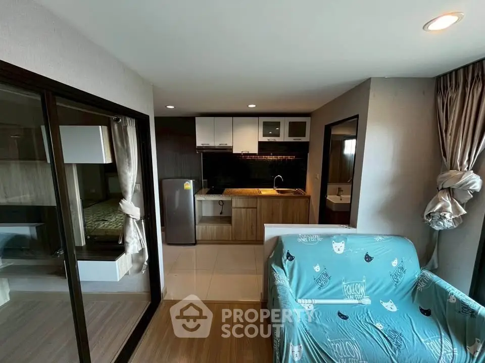 Modern open-layout living room with kitchen and cozy decor in a stylish apartment.