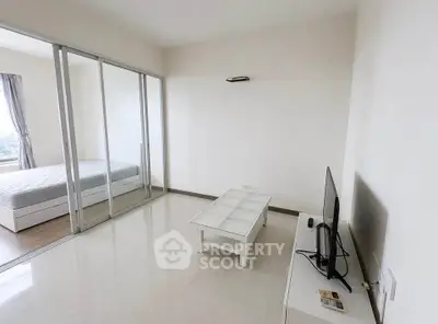 Modern apartment with sleek living room and cozy bedroom, featuring glass sliding doors and minimalist decor.