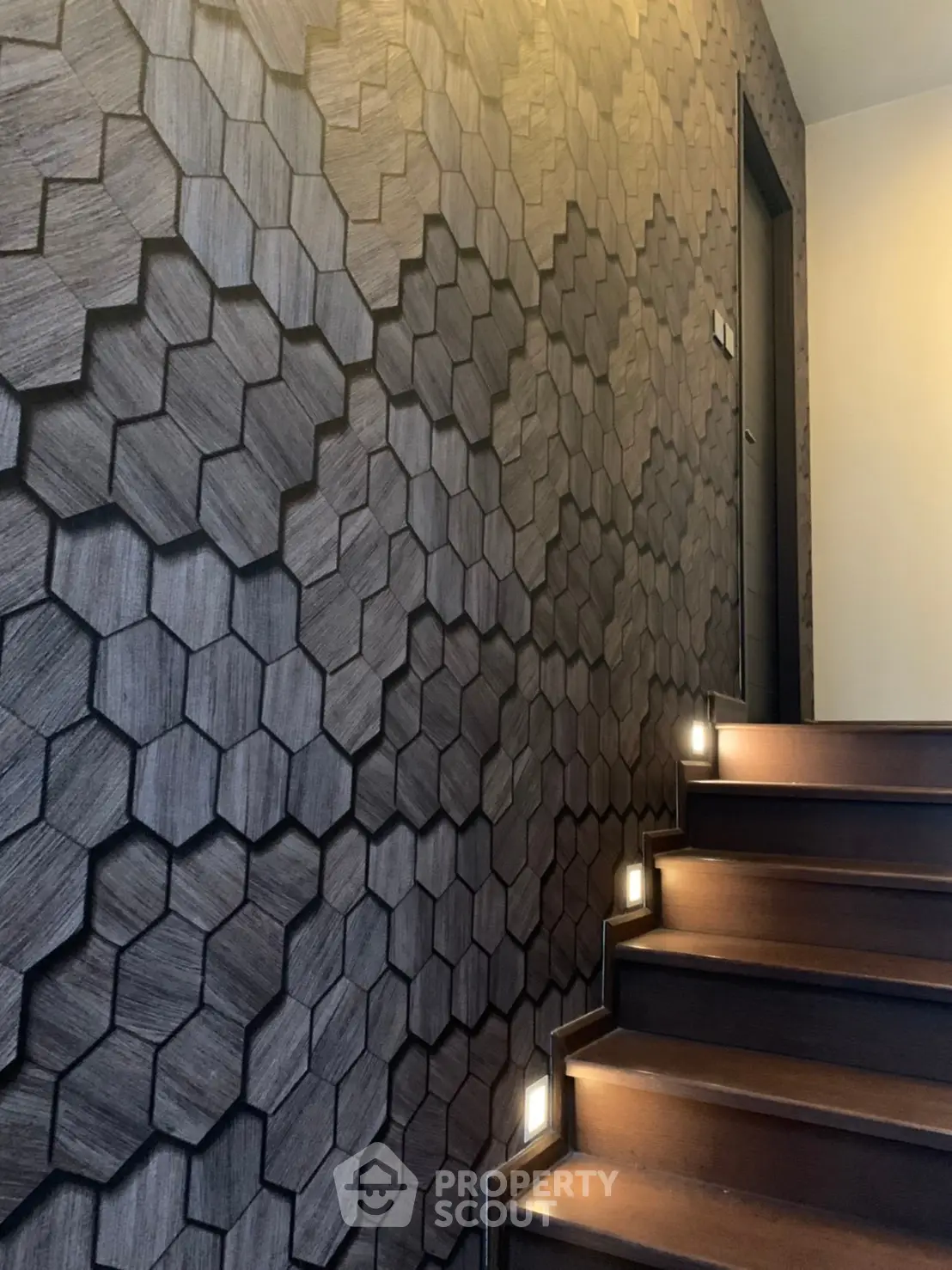 Elegant staircase with modern hexagonal wall design and ambient lighting