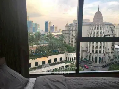 Stunning cityscape view from a cozy bedroom window, showcasing urban architecture and lush greenery.