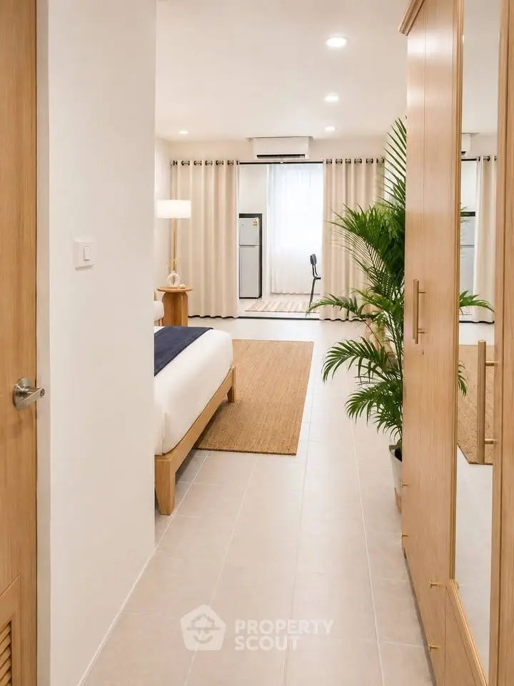 Spacious bedroom with modern decor and natural light, featuring a cozy bed and stylish furnishings.