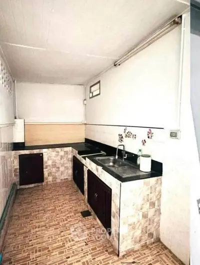 Charming kitchen with tiled countertops and backsplash, featuring a double sink and ample storage space.