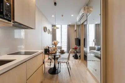 Modern open-layout kitchen and living room with stylish decor and natural light.