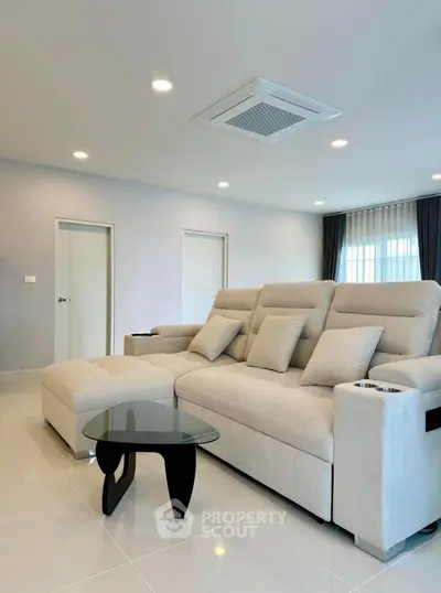 Spacious modern living room with elegant beige sofa and stylish glass coffee table