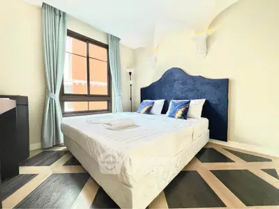 Luxurious bedroom with elegant decor and large window, featuring a stylish bed and modern lighting.