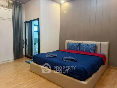 Spacious bedroom with modern decor and cozy ambiance, featuring a large bed and elegant lighting.