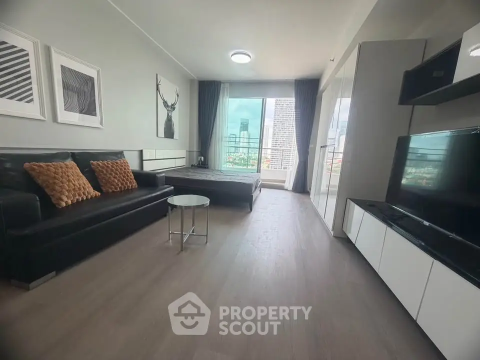 Modern living room with sleek furniture and city view from large window.