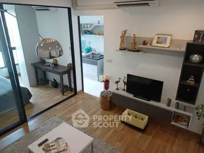 Modern living room with stylish decor and open view into bedroom and kitchen