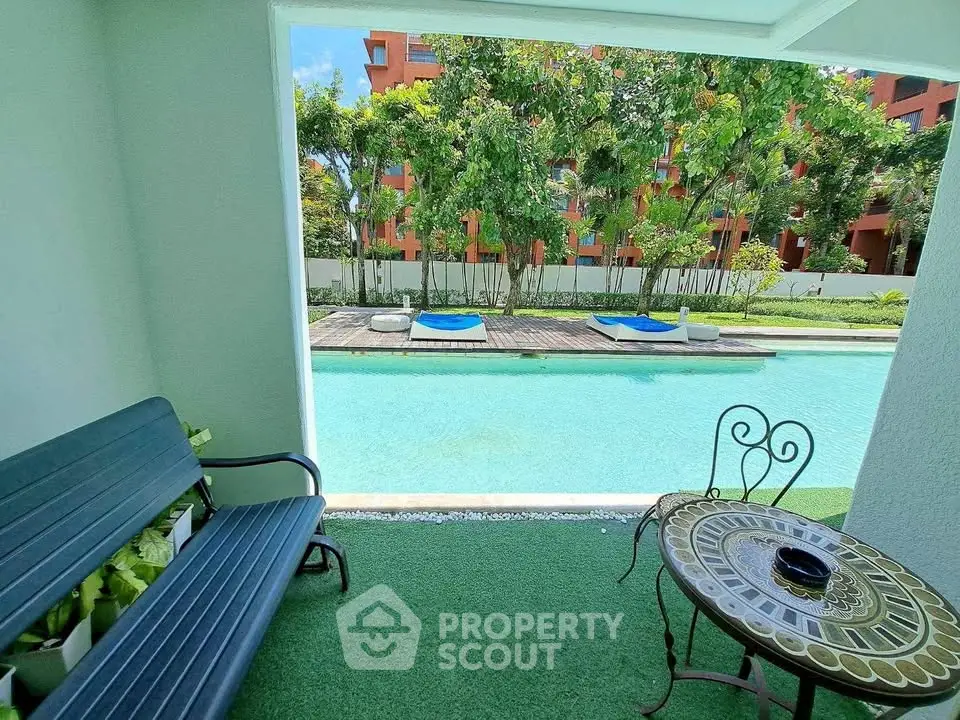 Charming poolside view with cozy seating area in a lush garden setting, perfect for relaxation.