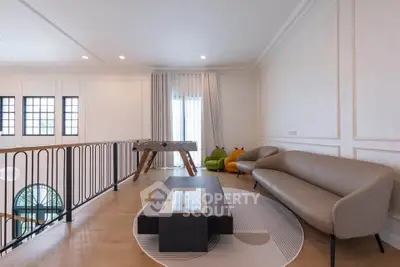 Spacious living area with modern furniture and natural light, perfect for relaxation and entertainment.