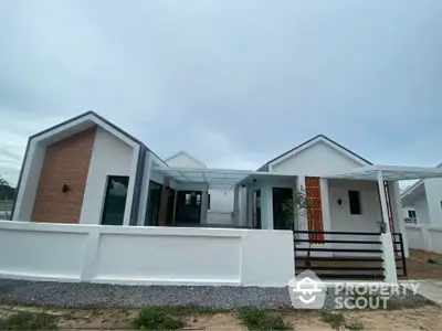 Modern minimalist single-story house with unique architectural design and spacious outdoor area.