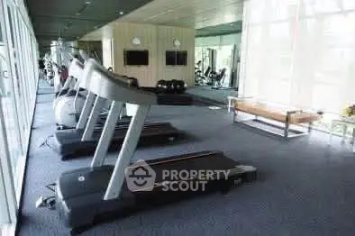 Spacious modern gym with treadmills and fitness equipment in a well-lit area.