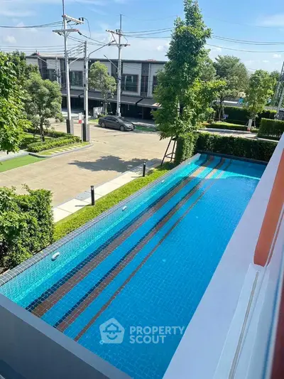 Luxurious modern swimming pool with serene surroundings and lush greenery, perfect for relaxation and leisure.