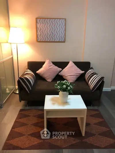 Cozy living room with stylish sofa, decorative pillows, and ambient lighting for a warm atmosphere.