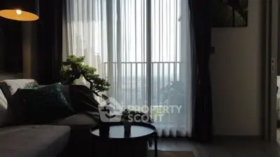 Modern living room with large window and balcony view, featuring stylish decor and cozy seating area.
