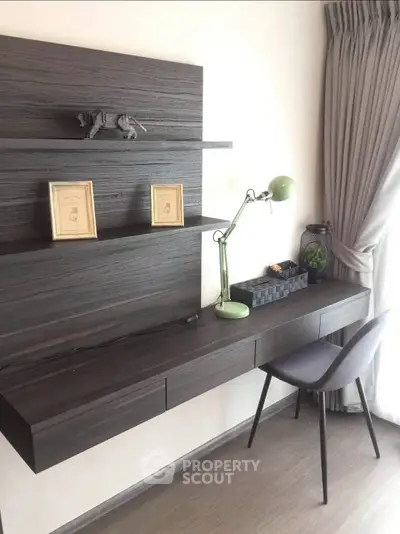 Modern study area with sleek desk, stylish chair, and decorative shelves in a bright room.