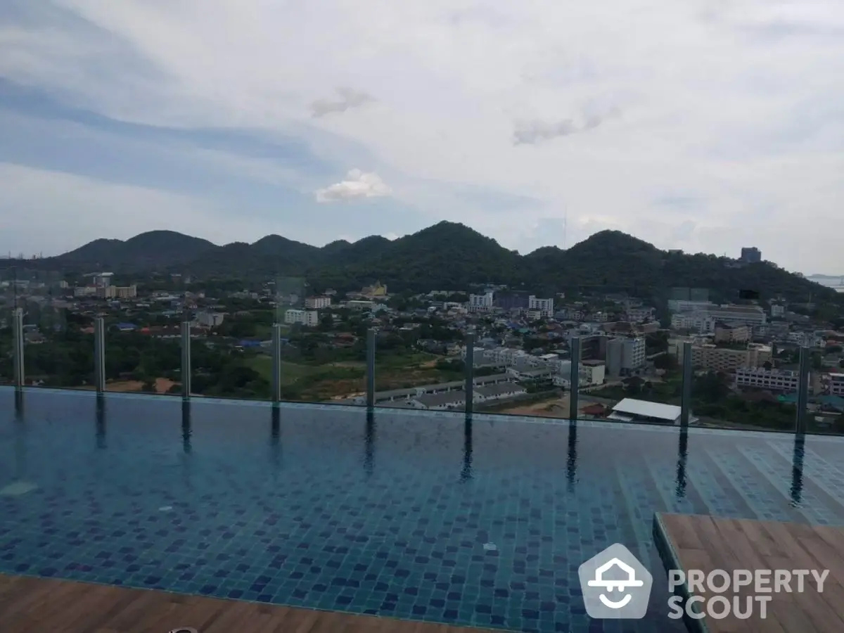 Stunning rooftop pool with panoramic mountain views in a luxury high-rise building.