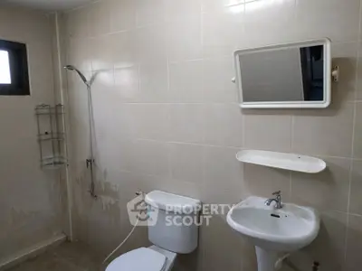 Spacious bathroom with modern fixtures and neutral tiles, featuring a shower and a large mirror.