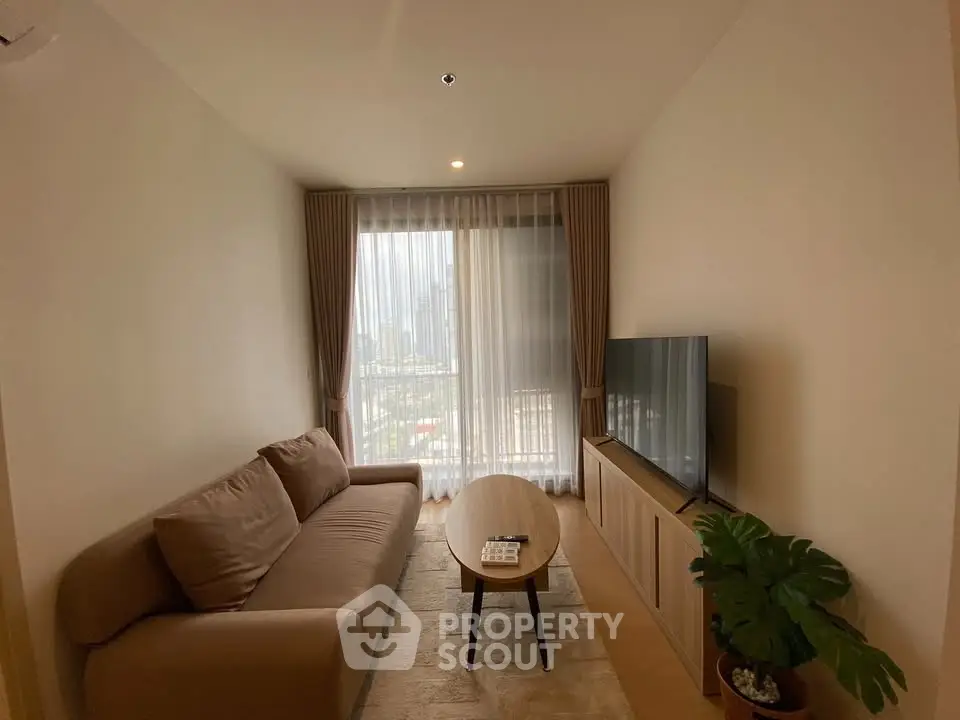Cozy living room with large window and modern furnishings in a stylish apartment.