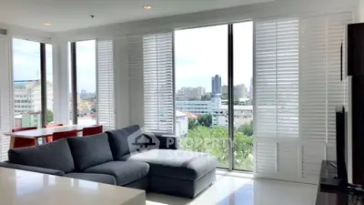 Spacious modern living room with panoramic city views and sleek furnishings.