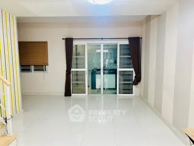 Spacious modern living room with sleek tiled flooring and large windows for natural light.