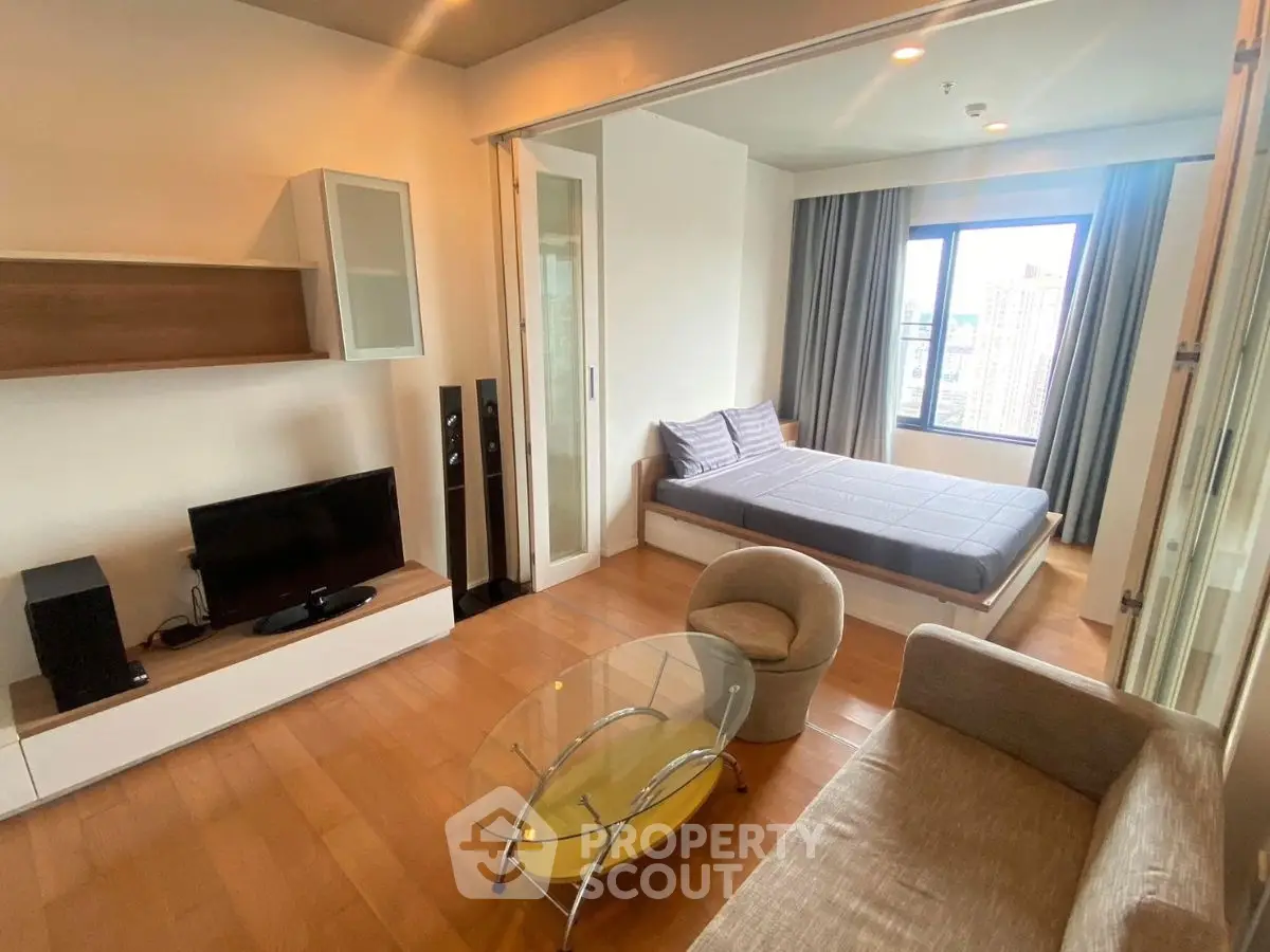 Modern studio apartment with open layout and city view, featuring cozy living area and stylish furnishings.