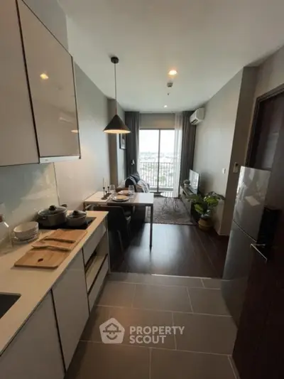 Modern open-layout kitchen and living room with sleek design and natural light.