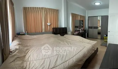 Spacious bedroom with large bed and mirrored wardrobe, perfect for relaxation.