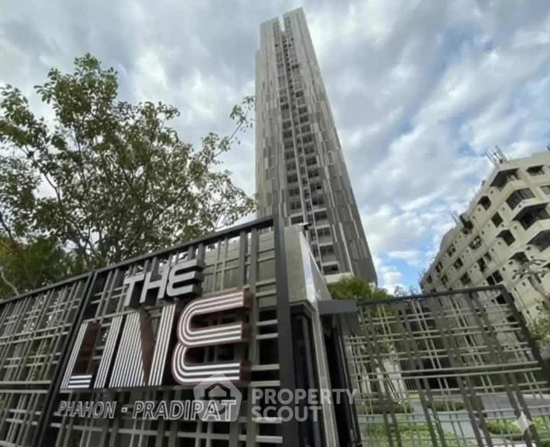 Modern high-rise building with stylish entrance gate and urban surroundings.